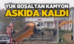 Yük boşaltan kamyon askıda kaldı